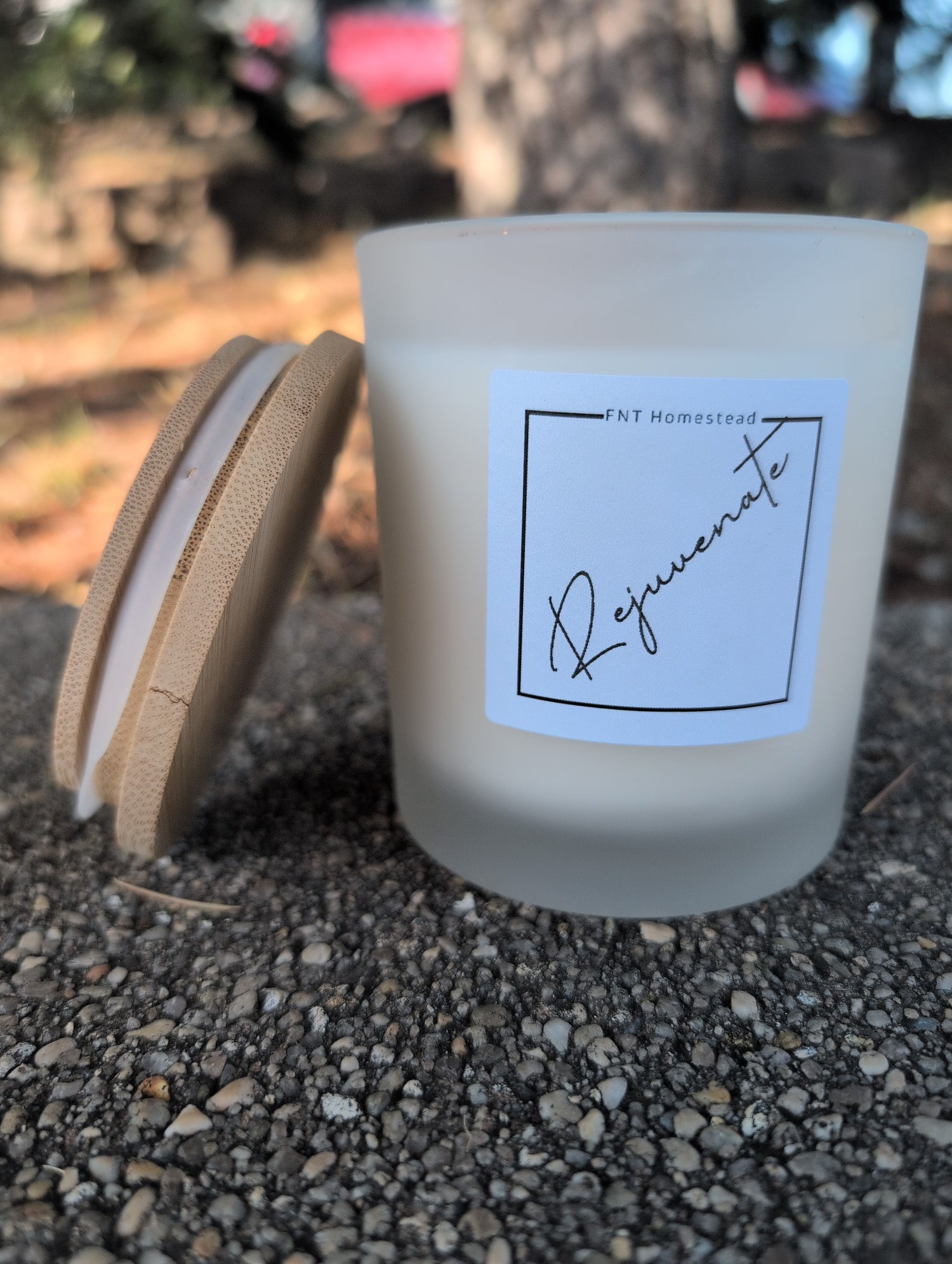 White candle with a label on a textured surface